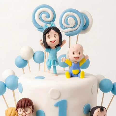 Detalle de figuritas de fondant de bebé y niña con paletas en espiral y globos azules sobre pastel de bautizo, L'Autrichienne CDMX