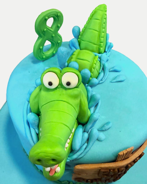 Vista superior del pastel de cocodrilo con número de edad en fondant L'Autrichienne CDMX