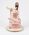 Pastel de Harry Potter rosa y dorado de dos pisos con figura de Hermione, snitch dorada y lechuza de fondant, L'Autrichienne CDMX