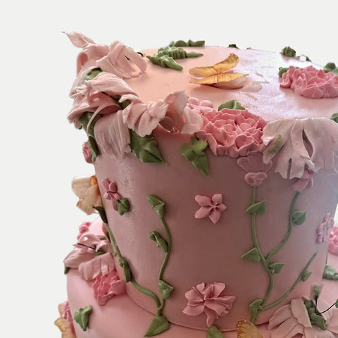 Detalle de rosas, pétalos y mariposa en la orilla del pastel L'Autrichienne CDMX