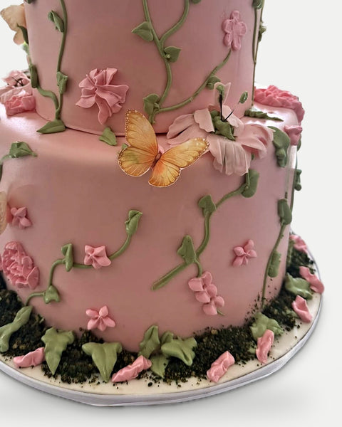 Mariposa dorada sobre las flores y base de tierra de jardín L'Autrichienne CDMX