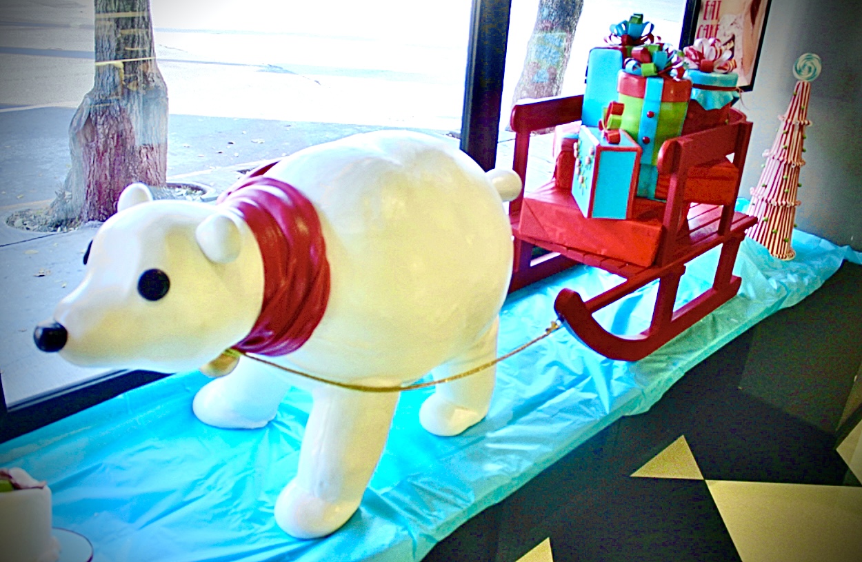 Se muestra un pastel con forma de oso polar arrastrando un trineo